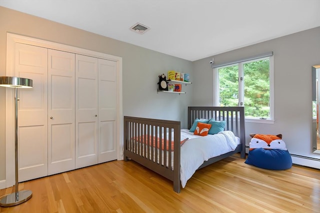 28 Smithshire Ests, Andover, MA 01810 - bedroom featuring light wood finished floors, a closet, and a baseboard radiator
