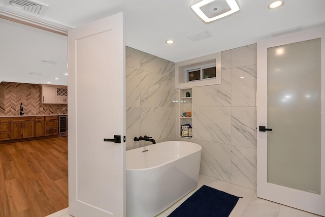 28 Smithshire Ests, Andover, MA 01810 - bathroom featuring a freestanding bath, recessed lighting, wine cooler, tile walls, and vanity