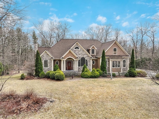 7 Buckhide Rd, Windham, NH 03087 - view of front of property with stone siding, a front yard, and a chimney