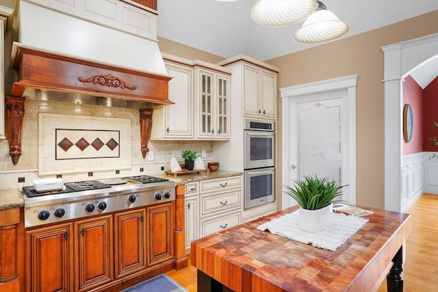 7 Buckhide Rd, Windham, NH 03087 - kitchen featuring stainless steel appliances, wooden counters, custom exhaust hood, glass insert cabinets, and backsplash