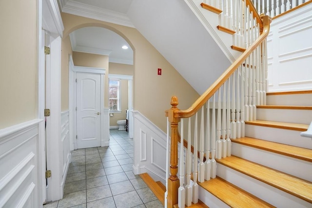 7 Buckhide Rd, Windham, NH 03087 - staircase with arched walkways, a decorative wall, ornamental molding, a wainscoted wall, and tile patterned floors