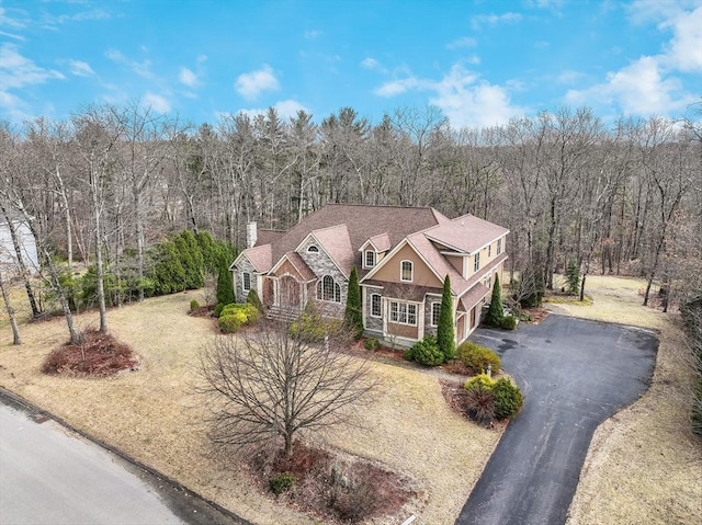 7 Buckhide Rd, Windham, NH 03087 - view of front of home featuring driveway, a wooded view, a chimney, a garage, and stone siding