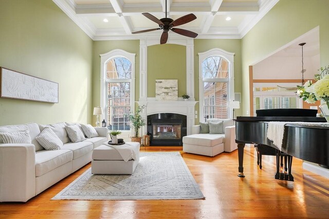 7 Buckhide Rd, Windham, NH 03087 - living area with coffered ceiling, ceiling fan, beamed ceiling, wood finished floors, and a multi sided fireplace