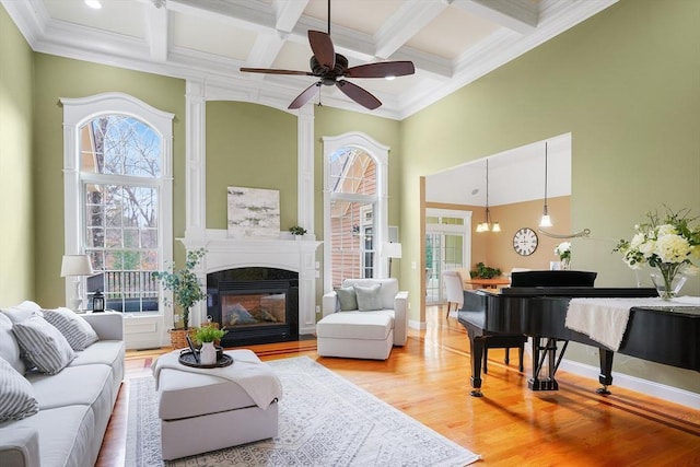 7 Buckhide Rd, Windham, NH 03087 - living room featuring plenty of natural light, a glass covered fireplace, a ceiling fan, light wood finished floors, and beam ceiling