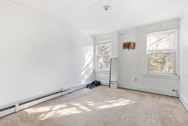 carpeted spare room with a baseboard heating unit