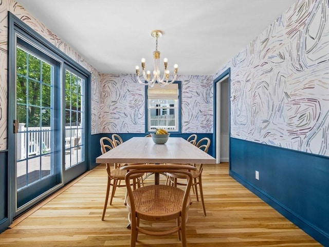 dining space featuring wallpapered walls, a chandelier, light wood-type flooring, and baseboards