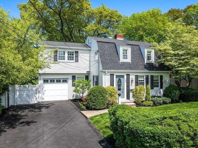 dutch colonial with asphalt driveway, fence, a shingled roof, a garage, and a chimney