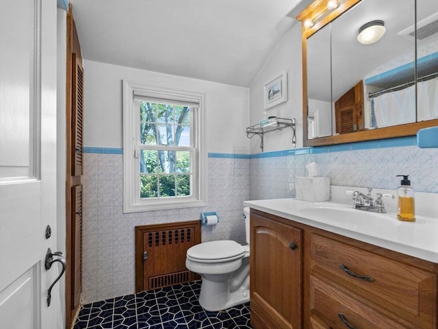 full bathroom featuring radiator, tile walls, vaulted ceiling, tile patterned flooring, and toilet