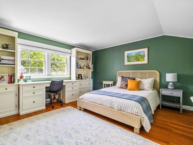 bedroom featuring vaulted ceiling, wood finished floors, and an office area