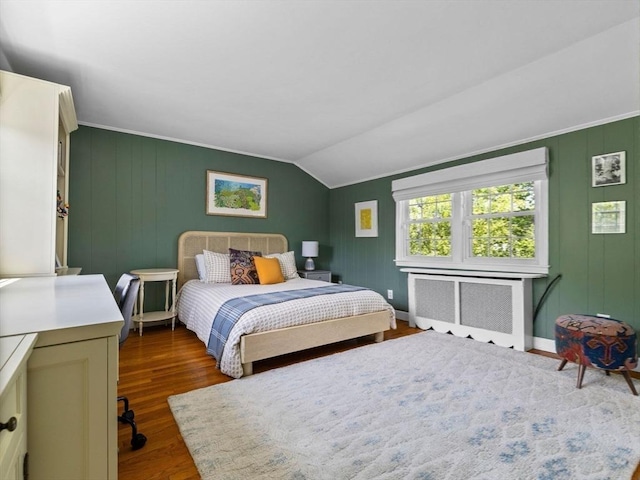 bedroom featuring radiator, dark wood-type flooring, vaulted ceiling, and baseboards