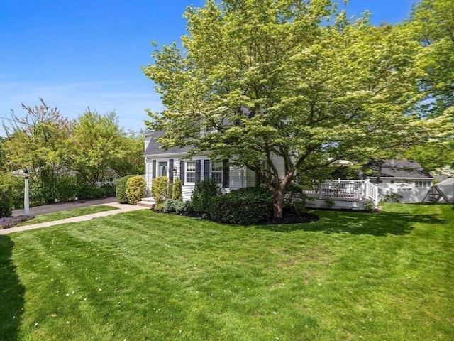 view of grassy yard with a deck