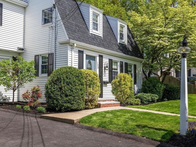 view of front of home featuring a front lawn and roof with shingles