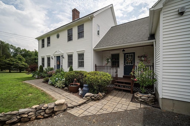 769 Federal St, Belchertown, MA 01007 - view of front of house featuring a chimney, a front yard, a porch, and a shingled roof