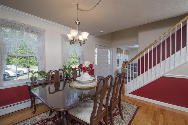 769 Federal St, Belchertown, MA 01007 - dining area with a chandelier, baseboard heating, stairway, wood finished floors, and crown molding