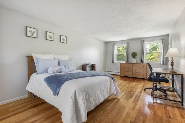2 Harding Rd, Medway, MA 02053 - bedroom featuring a baseboard heating unit, light wood finished floors, and a textured ceiling