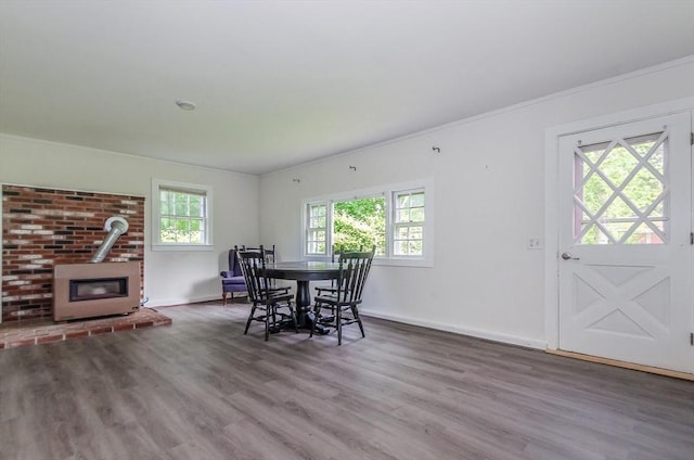 10 Briggs Ln, Marion, MA 02738 - dining space featuring a wood stove, wood finished floors, baseboards, and crown molding