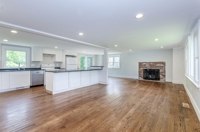 10 Briggs Ln, Marion, MA 02738 - kitchen with freestanding refrigerator, stainless steel dishwasher, dark countertops, wood finished floors, and white cabinetry