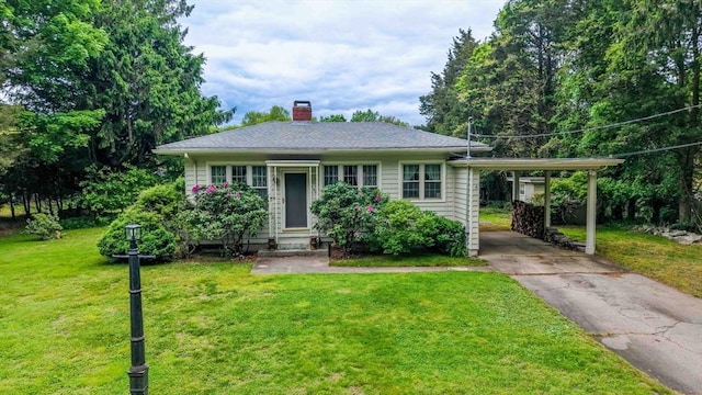 16 Stoneledge Rd, Dartmouth, MA 02748 - view of front facade with a chimney, concrete driveway, a front lawn, and an attached carport