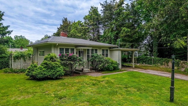 16 Stoneledge Rd, Dartmouth, MA 02748 - view of front of home with concrete driveway, a front yard, a carport, and a chimney