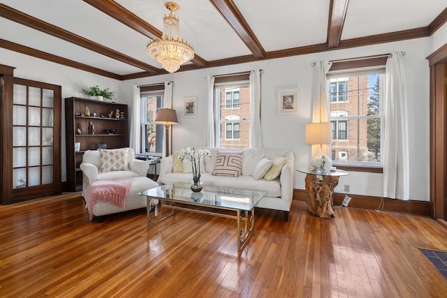 sitting room featuring hardwood / wood-style floors, plenty of natural light, ornamental molding, and beamed ceiling