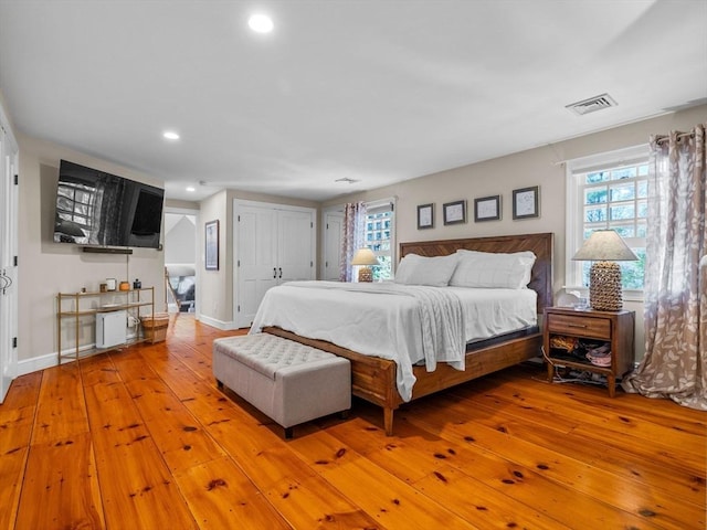 bedroom with light wood-style floors, baseboards, recessed lighting, and visible vents