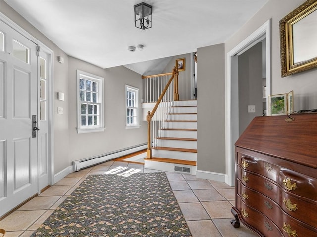 foyer entrance with baseboard heating, tile patterned flooring, stairs, baseboards, and visible vents