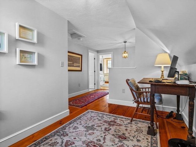 home office with baseboards, a textured ceiling, and wood finished floors