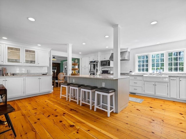kitchen featuring white cabinets, black microwave, a sink, and tasteful backsplash