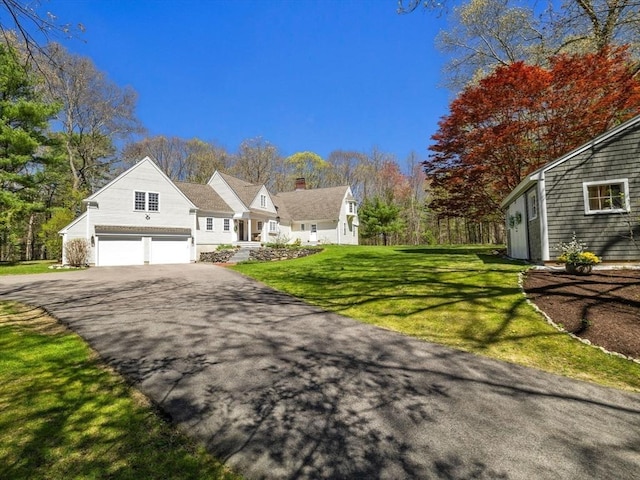view of front facade with a garage, driveway, and a front yard