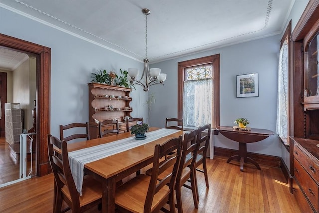 dining room with crown molding and light wood-type flooring