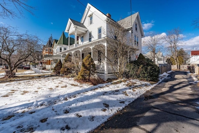 view of snowy exterior featuring covered porch