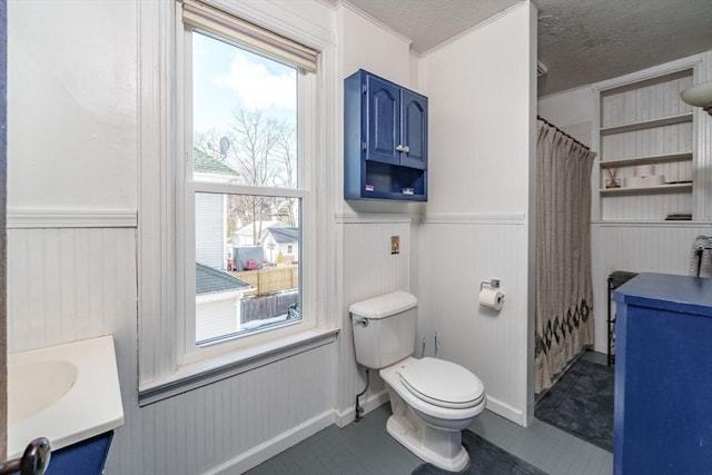 bathroom with vanity, toilet, curtained shower, and a textured ceiling