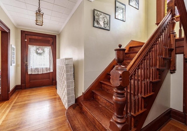 entryway featuring crown molding and light hardwood / wood-style floors