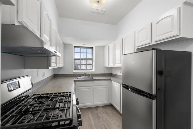 kitchen with stainless steel appliances, visible vents, a sink, and white cabinetry