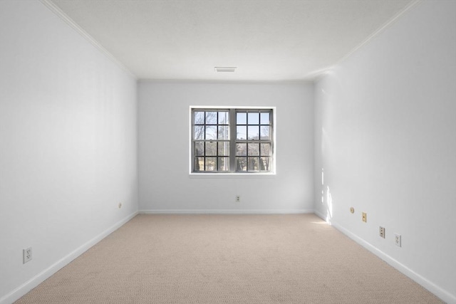 spare room featuring light colored carpet, crown molding, visible vents, and baseboards