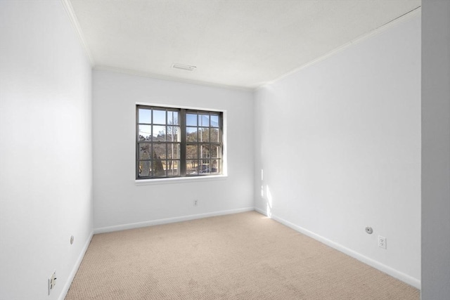 unfurnished room with carpet flooring, crown molding, visible vents, and baseboards