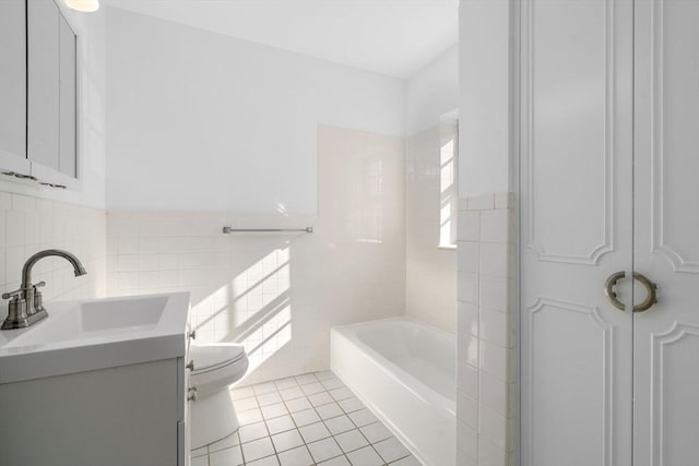 bathroom featuring tile walls, toilet, wainscoting, vanity, and tile patterned flooring