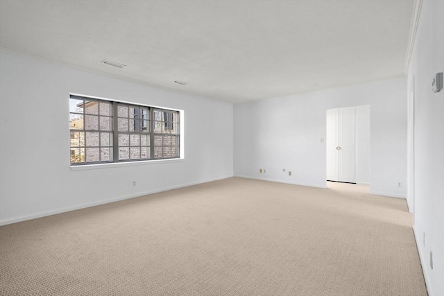 unfurnished room with baseboards, visible vents, and light colored carpet