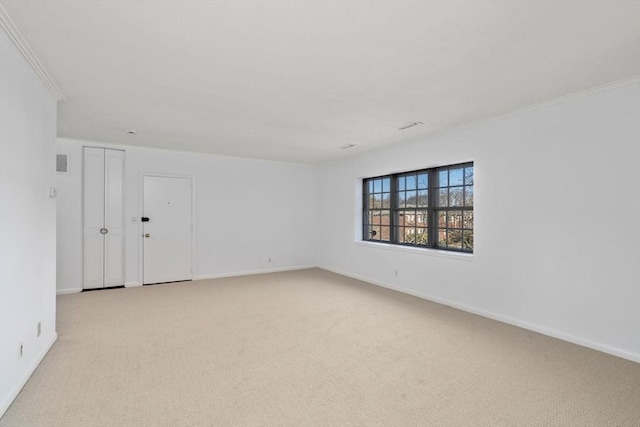 spare room featuring baseboards, visible vents, ornamental molding, and light colored carpet