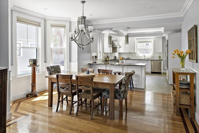 dining room featuring a chandelier, light wood finished floors, and ornamental molding