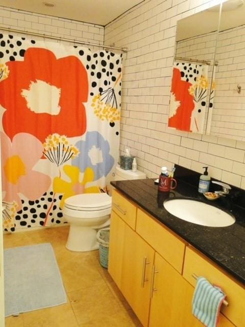 bathroom featuring vanity, tile patterned flooring, a shower with shower curtain, toilet, and tasteful backsplash