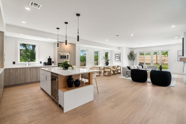 31 Evergreen St Unit 2, Boston, MA 02130 - kitchen featuring modern cabinets, wine cooler, recessed lighting, light wood-style flooring, and light countertops