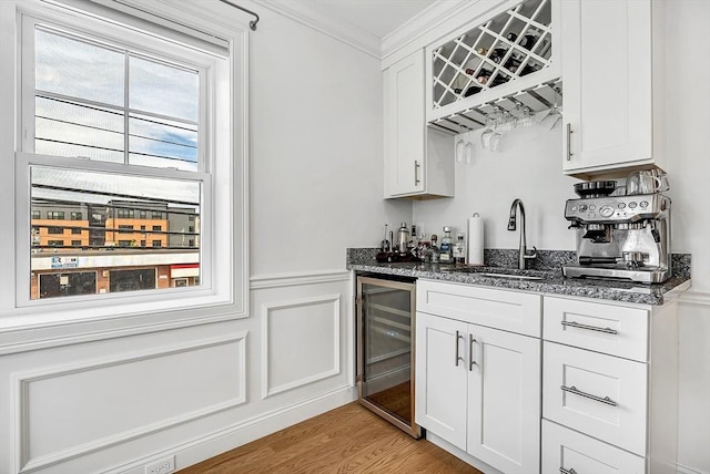 3 Lowell St Unit 1, Waltham, MA 02453 - indoor wet bar featuring beverage cooler, ornamental molding, light wood-type flooring, wainscoting, and a decorative wall