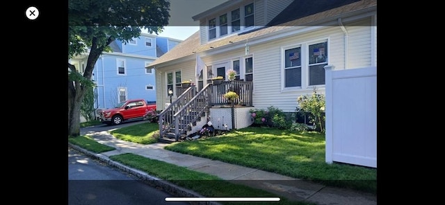 view of side of home featuring a lawn and stairway