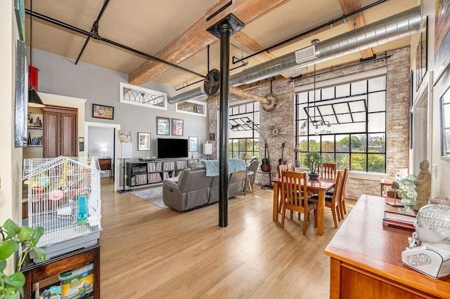 491 Dutton St Unit 411, Lowell, MA 01854 - dining space featuring a towering ceiling, wood finished floors, healthy amount of natural light, and beam ceiling