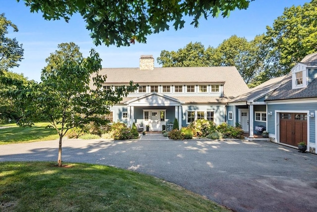 14 Reiling Pond Rd, Lincoln, MA 01773 - shingle-style home featuring a porch, a chimney, driveway, and a front lawn