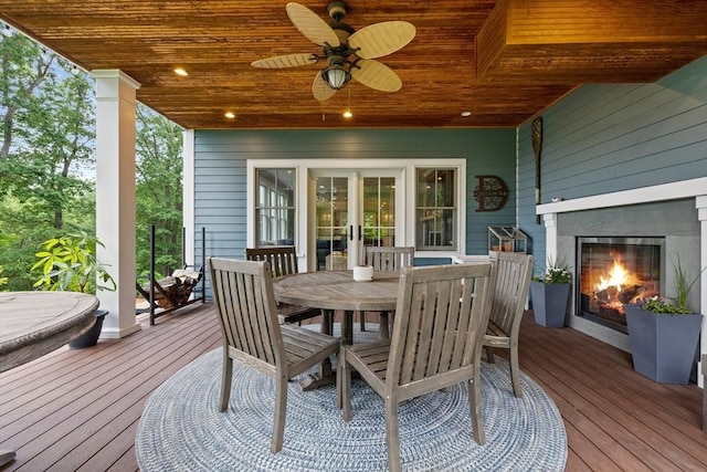 14 Reiling Pond Rd, Lincoln, MA 01773 - wooden terrace featuring a glass covered fireplace, outdoor dining space, and a ceiling fan