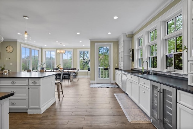 14 Reiling Pond Rd, Lincoln, MA 01773 - kitchen with beverage cooler, dark countertops, ornamental molding, stainless steel dishwasher, and white cabinets