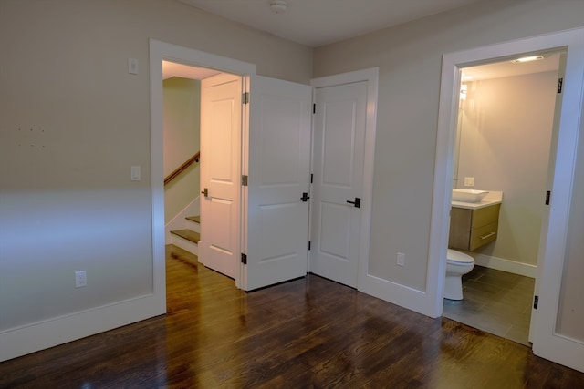 bedroom with dark hardwood / wood-style floors and ensuite bath