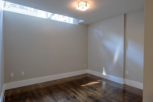 unfurnished room with dark hardwood / wood-style floors and plenty of natural light